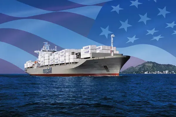 澳门十大赌厅app下载 ship loaded with containers arriving Honolulu with imposed American flag in the background.